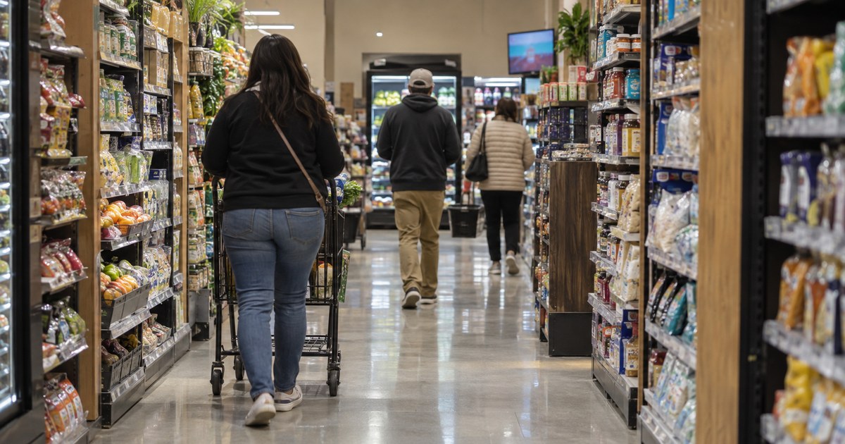 Illustrative image: A view along a store walkway with shoppers and a screen visible in the middle distance