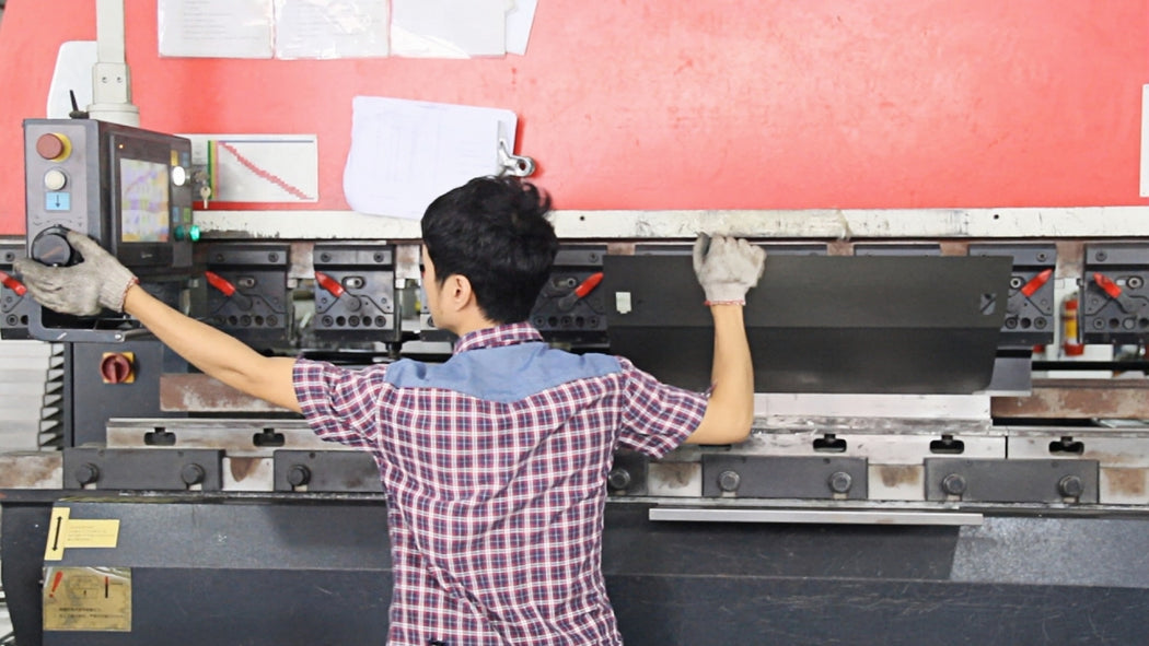 A metal sheet positioned at a CNC press brake