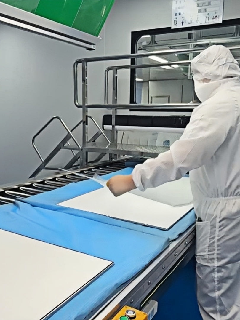 A worker handling material at a display module assembly station